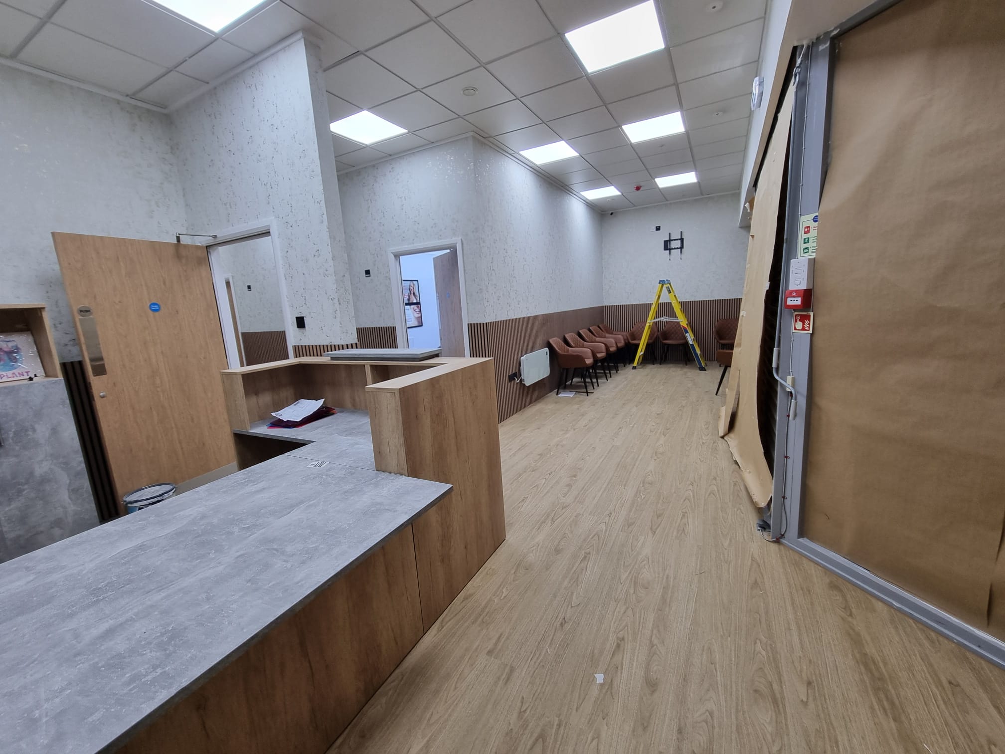 A spacious room with a high ceiling and white walls, giving it an airy feel