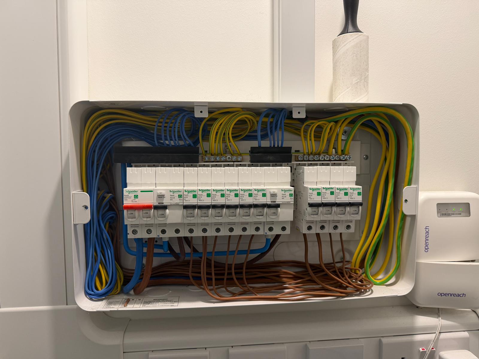 A detailed view of an electrical panel mounted on a white wall in what appears to be a residential or commercial setting