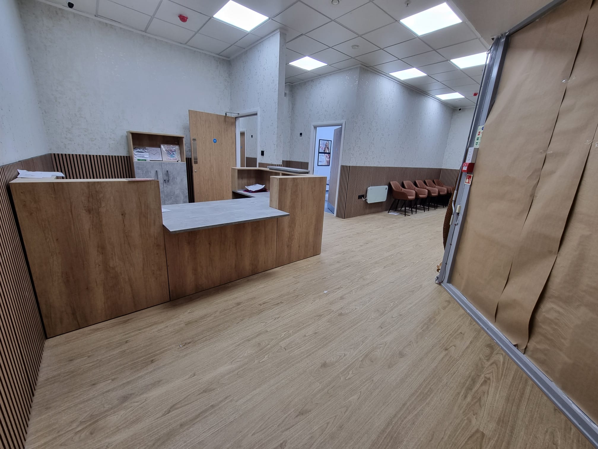 A serene office space bathed in natural light filtering through a large window on the right side